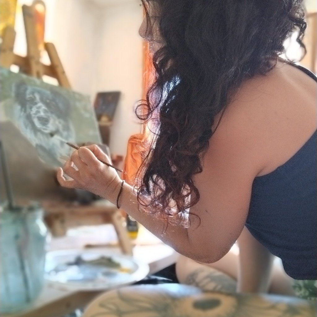 Artista de aniMaMundiM pintando en su caballete de madera
