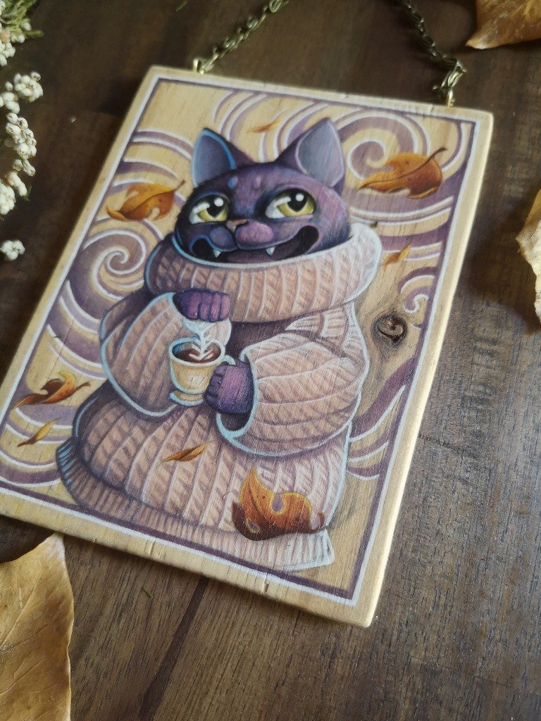 Gato con suéter tomando café